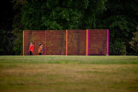 Coloured mesh sculpture in front of trees